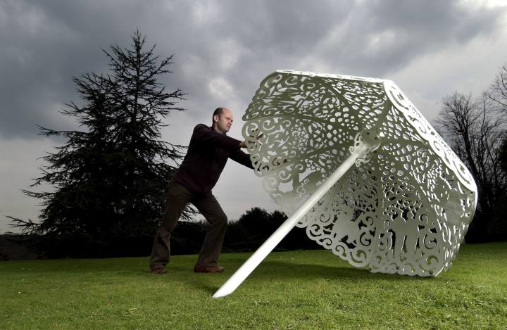 Sculptor Bruce Williams arranges his steel canopy "Parasol" in the garden of the National Trust's Polesden Lacey
